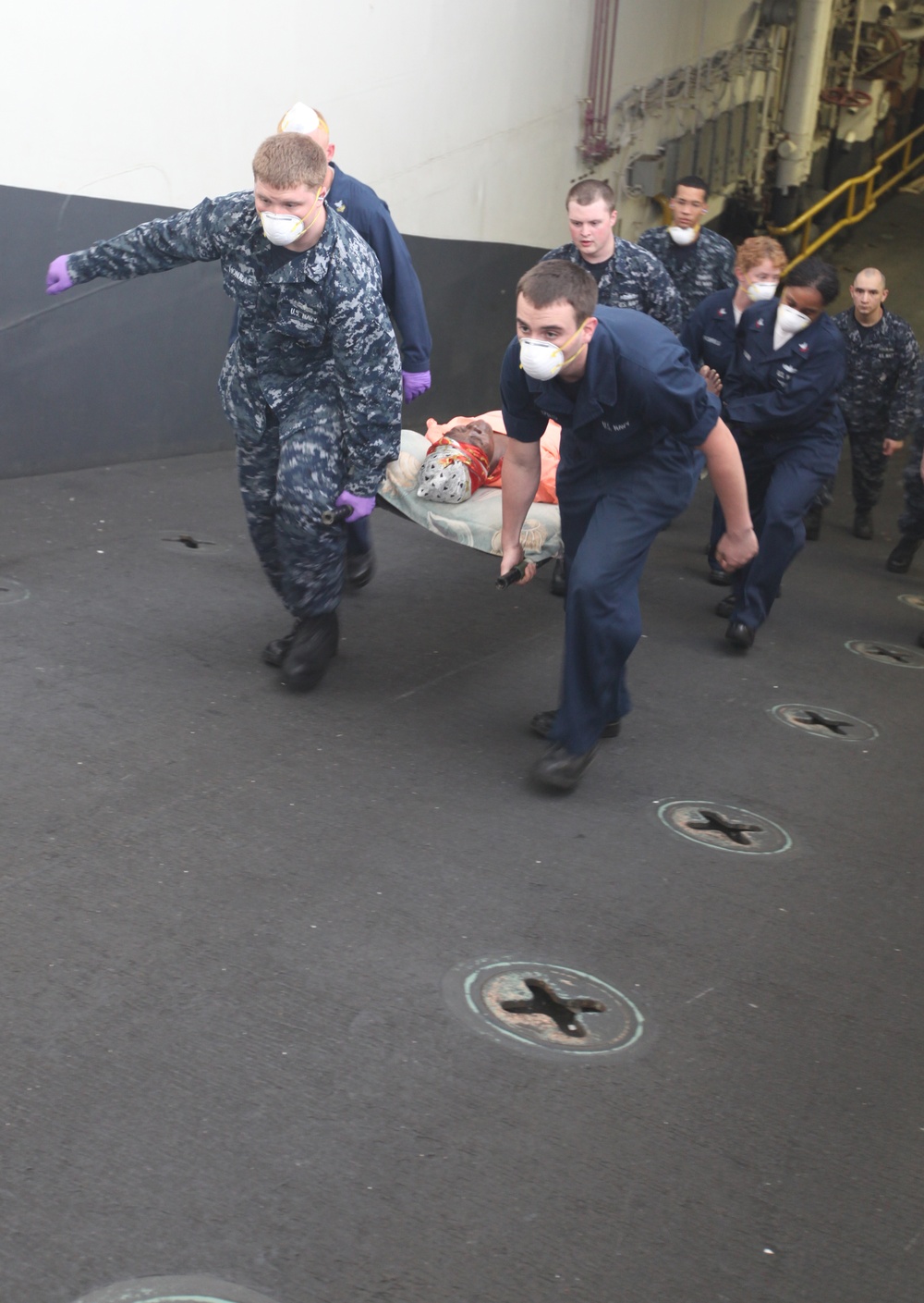 Sailors aboard USS Bataan, attend to a Haitian woman and child during a casualty evacuation