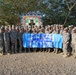 Task Force 1st Medical Brigade Members Pose With a Poster From Sunrise Valley Elementary School