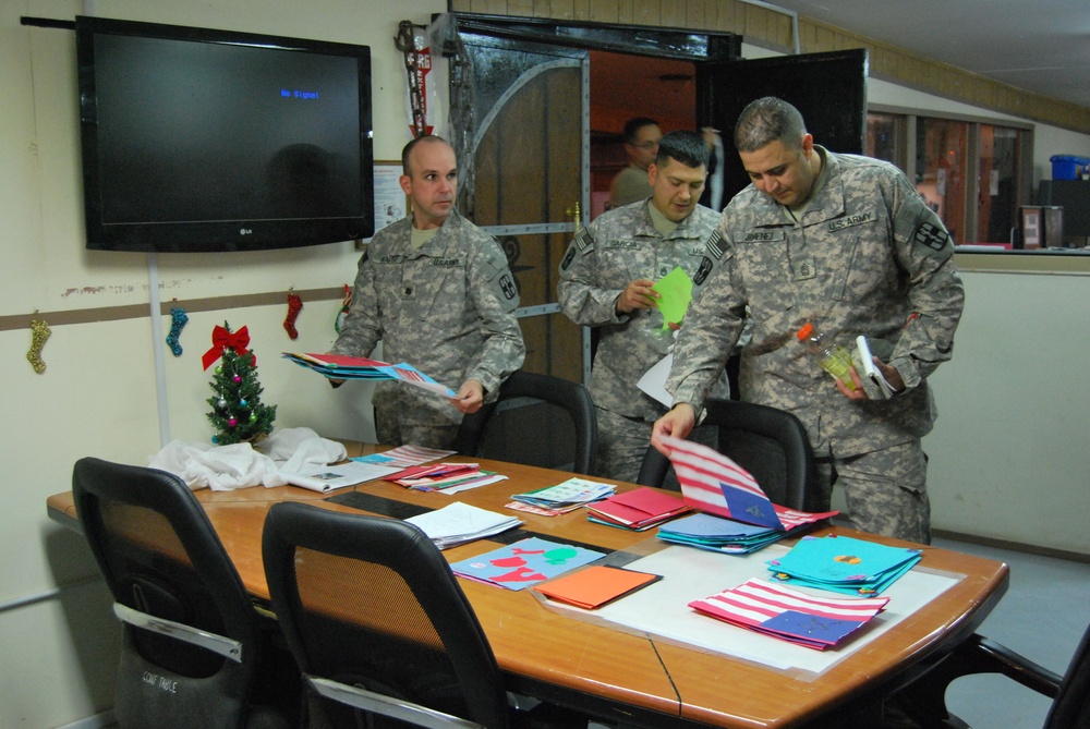 TF 1 MED soldiers look through card made by elementary students