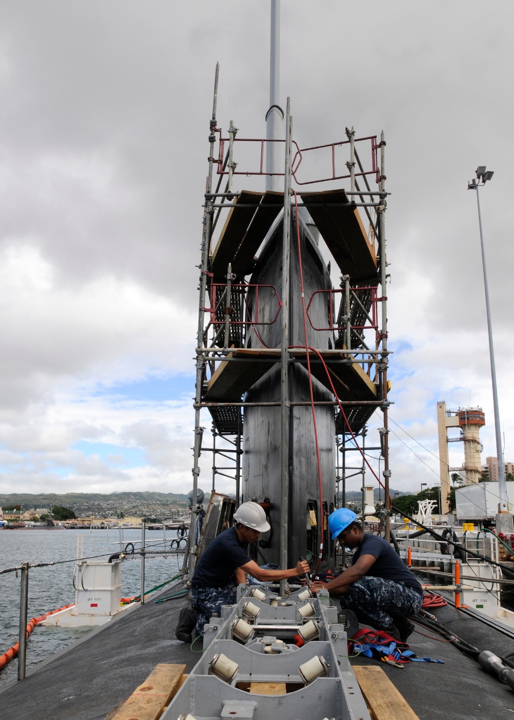 Sailors performs maintenance on submarine