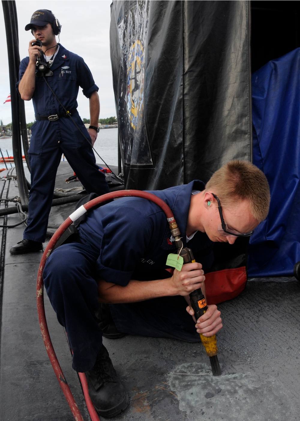 Sailor performs maintenance on submarine outer deck