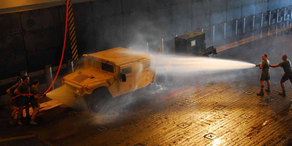 Marines wash down Humvee aboard USS Bonhomme Richard