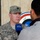 217th Military Police Train Iraqi Police at the Criminal Justice Center A U.S. Army Captain named Worthy, wearing ACU (Army Combat Uniform) digital camouflage, is being interviewed by a reporter from Al Sumaria, an Iraqi television network. The soldier faces the camera while a civilian interviewer holds a blue Al Sumaria-branded microphone toward him. A circular emblem featuring the Iraqi flag colors is visible in the background.