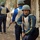 217th Military Police train Iraqi police at the Criminal Justice Center The image shows a group of armed security or police personnel in a street or outdoor setting. They are wearing blue uniforms with yellow striping, body armor vests, and military-style helmets. The foreground figure is holding a rifle and looking directly at the camera.