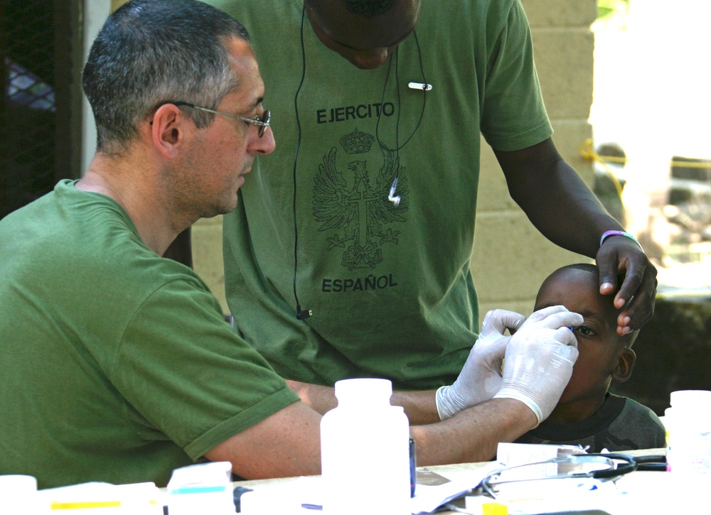 A medical doctor with the Spanish Marines renders medical aid to a Haitian Boy