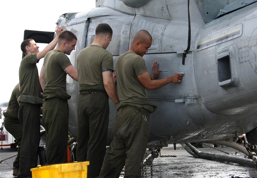 Marines from HMH 461 (Reinforced), 22nd MEU, wash a UH-1N Huey helicopter