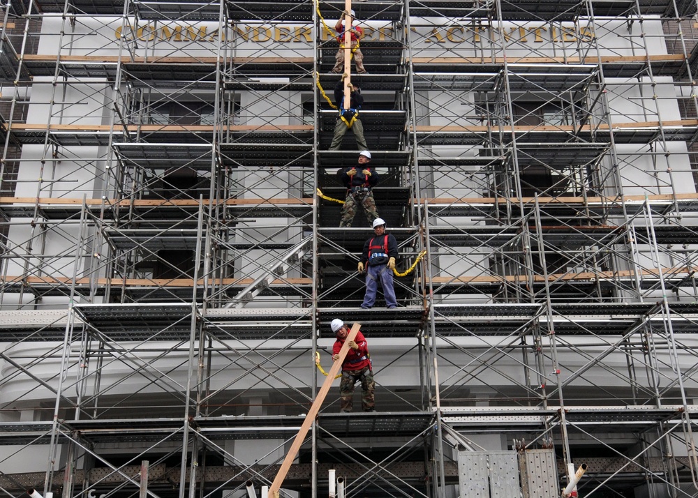 Contract Japanese workers remove scaffolding