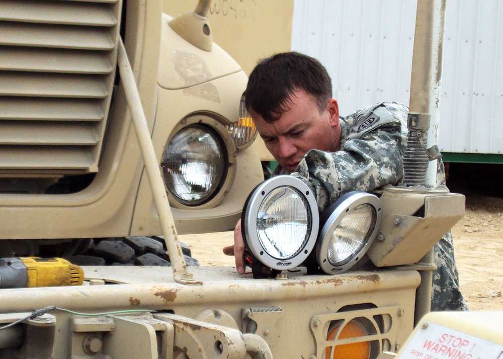 U.S. military convoy escorts install donated off-road lights