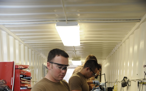 Service members clean weapons