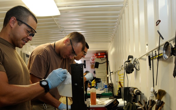 Service members clean weapons