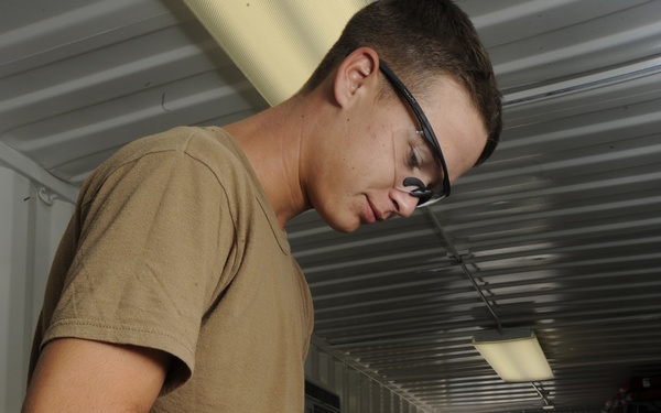 Service members clean weapons