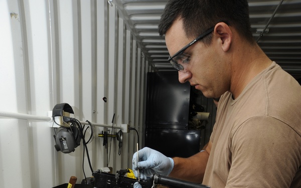 Service members clean weapons