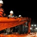 Workers Move Oil Containment Boom Onto a Supply Boat