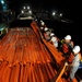 Workers Move Oil Containment Boom Onto a Supply Boat