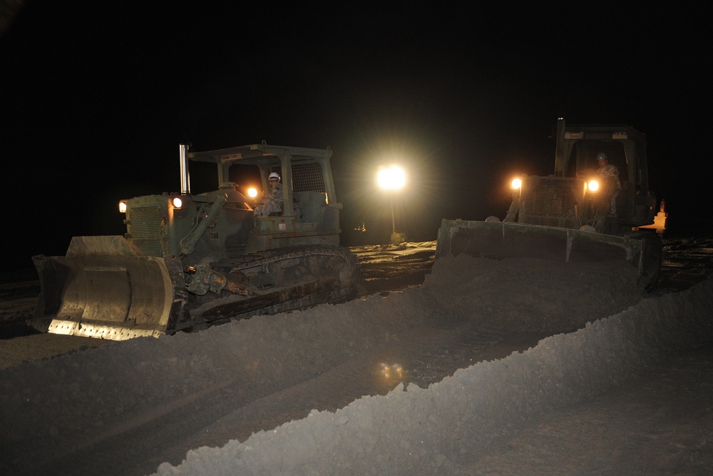 Louisiana National Guard's work around the clock bulldozing sand to close a strait between two peninsulas in Grand Isle