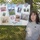 A woman wearing a gray 'USN Navy Mom' t-shirt stands in front of a chain-link fence displaying a collage poster for Fleet Week 2010. The poster features photographs representing all five branches of the U.S. military: Army, Air Force, Navy, Marines, and Coast Guard. The setting appears to be an outdoor public event, likely a Fleet Week celebration.