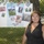 A woman stands in front of a chain-link fence to which a poster board is attached. The poster is a Fleet Week 2010 display featuring photographs of military personnel from all five branches of the U.S. armed forces. The setting appears to be an outdoor event on a sunny day with green grass and trees visible in the background.