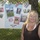 A smiling blonde woman stands in front of a poster board attached to a chain-link fence. The poster is a military-themed collage celebrating 'Fleet Week 2010,' featuring labels for all five U.S. military branches and several personal photographs. The setting appears to be an outdoor event on a sunny day with green trees and grass visible in the background.