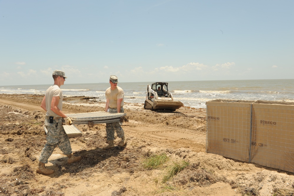 Louisiana National Guardsmen construct a Hesco Concertainer barrier wall along portions of the Cameron Parish coastline