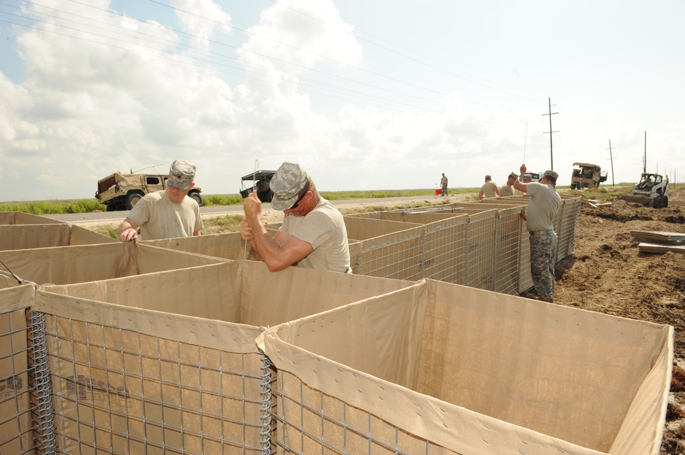 Louisiana National Guardsmen construct a Hesco Concertainer barrier wall along portions of the Cameron Parish coastline