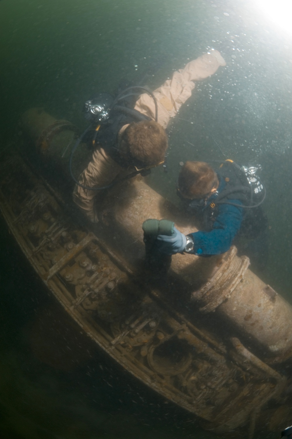 Navy divers work to lift sunken engine block
