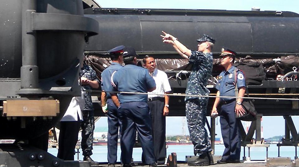 Sub commander talks to security during port visit