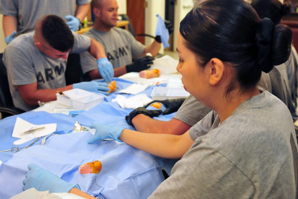 1st Armored Division medics practice suturing on pig's feet