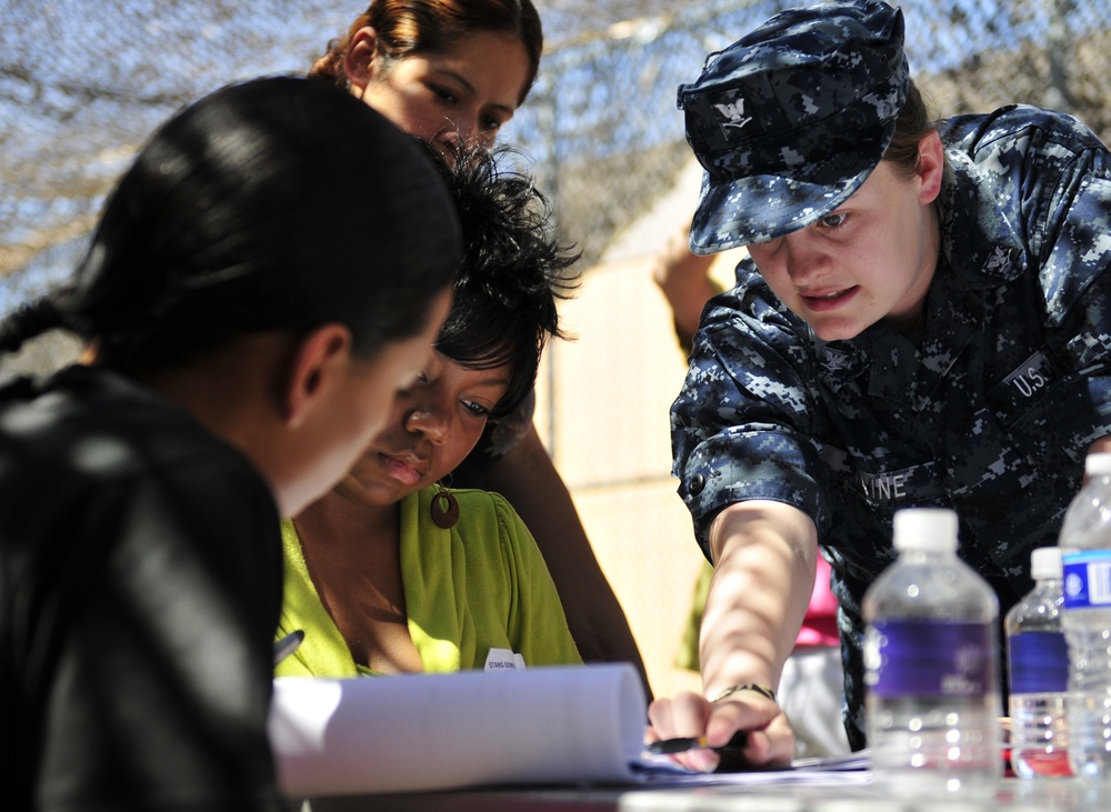 Petty Officer 3rd Class Terra Maine, quartermaster, assigned to Navy Legal Services Office Southwest, explains a legal document to attendees of the Veteran's Village of San Diego Stand Down 2010. Stand Down is a three-day event in a tent city where up to