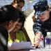 Petty Officer 3rd Class Terra Maine, quartermaster, assigned to Navy Legal Services Office Southwest, explains a legal document to attendees of the Veteran's Village of San Diego Stand Down 2010. Stand Down is a three-day event in a tent city where up to