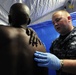 Petty Officer 3rd Class Ian Polage, hospital corpsman, assigned to Naval Medical Center San Diego, checks a shoulder injury on Edward Patterson, a Marine Corps veteran, during triage inside the Veteran's Village of San Diego Stand Down 2010 medical tent.