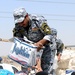 Artillerymen, policemen find thankful crowd during aid mission
A sergeant with the 1st Federal Police passes a box of bottled water to a group of Iraqi women during a humanitarian aid mission in northeastern Baghdad, July 17. In accordance with the Securi