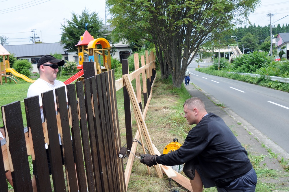 Sailors paint fence at children's home