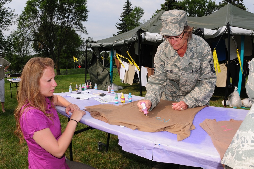 Master Sgt. Karen Erickson, of the 119th Wing, right, creates a t-shirt voicing her feelings against sexual assault, July 29, on the Veteran's Administration Hospital grounds in Fargo, N.D.  Erickson is being assisted by Staff Sgt. Heather Prigge, also of