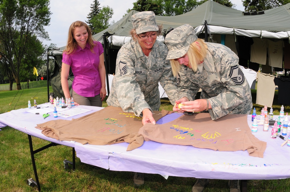 Senior Master Sgt. Susan Schroeder, right, and Master Sgt. Karen Erickson, both of the 119th Wing, create t-shirts voicing their feelings against sexual assault July 29, on the Veteran's Administration Hospital grounds in Fargo, N.D. Schroeder and Erickso