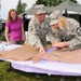 Senior Master Sgt. Susan Schroeder, right, and Master Sgt. Karen Erickson, both of the 119th Wing, create t-shirts voicing their feelings against sexual assault July 29, on the Veteran's Administration Hospital grounds in Fargo, N.D. Schroeder and Erickso