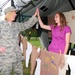 Senior Master Sgt. Susan Schroeder, left, gives a high five to Staff Sgt. Heather Prigge, both of the 119th Wing, as they hang a t-shirt on a clothesline project display, July 29, on the Fargo, N.D. Veteran's Administration Hospital grounds. The Clothesli
