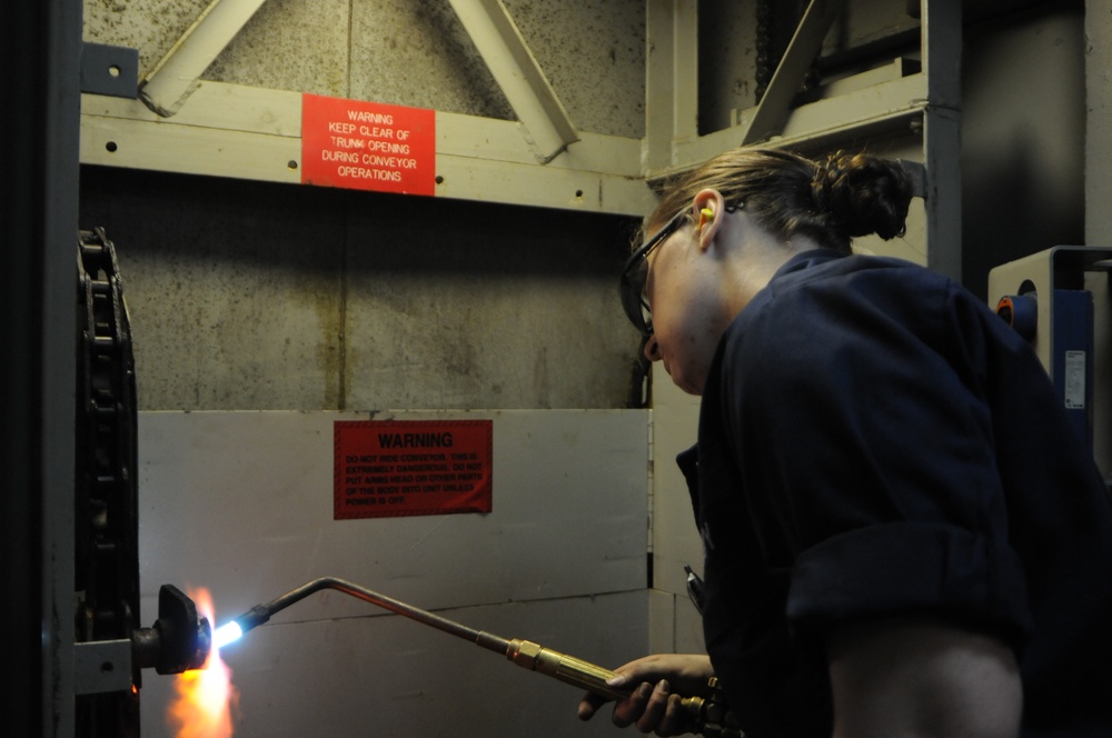 USS Wasp sailors repair a vertical conveyor