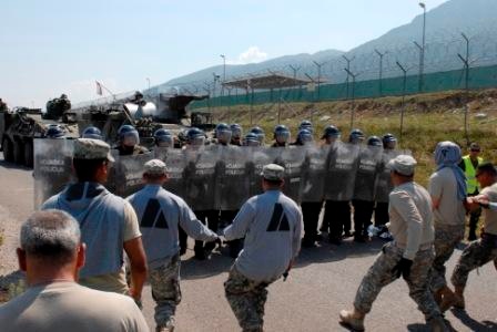 Multinational riot control training, U.S. soldiers play rioters