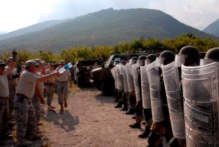 Multinational riot control training, U.S. soldiers play rioters