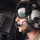 Supporting, transporting troops: HMH-361 flies across Helmand province A military aviator or crew member is photographed in close profile inside an aircraft, wearing a flight helmet with visor and boom microphone. The visor reflects an arid desert landscape with what appears to be a body of water or reservoir below, suggesting the aircraft is in flight over a desert region. The image captures both the subject and an environmental reflection simultaneously.