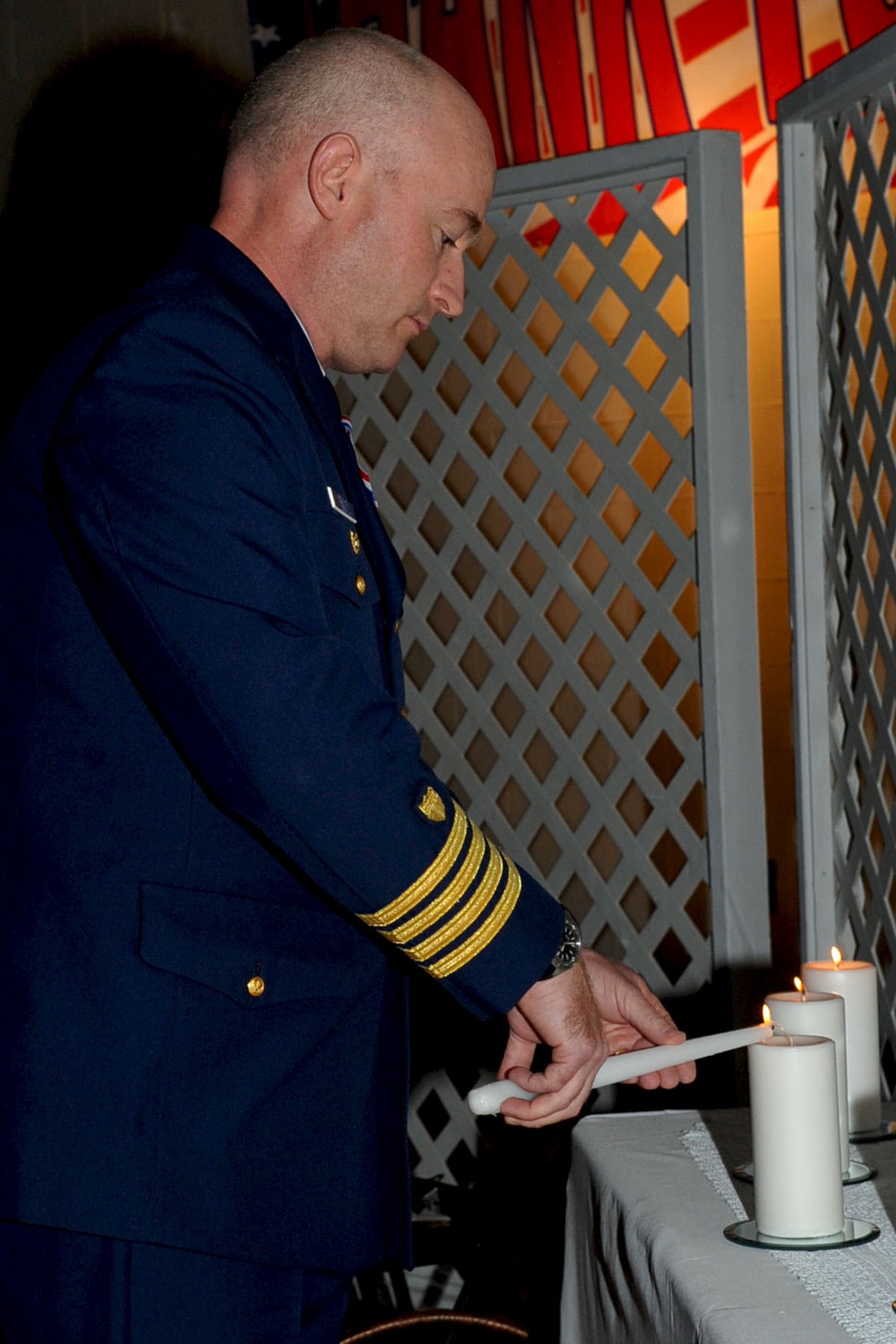 U.S. Coast Guard member Capt. Mahoney, lights a candle for his branch of service during the Veterans Day ceremony Nov. 4. The Niners Citizen's Club hosted the event at the South Norfolk Community Recreation Center to honor all active duty and retired mili