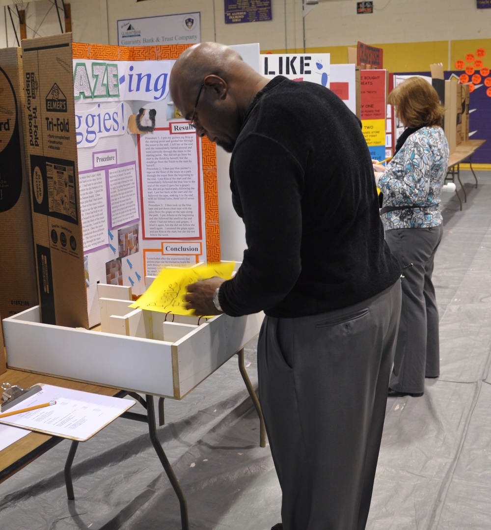 Technician steps outside supply box; judges local science fair entries