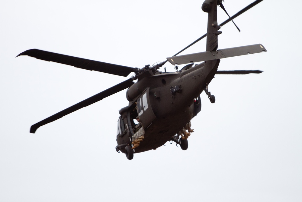 Paratroopers jump from helicopters