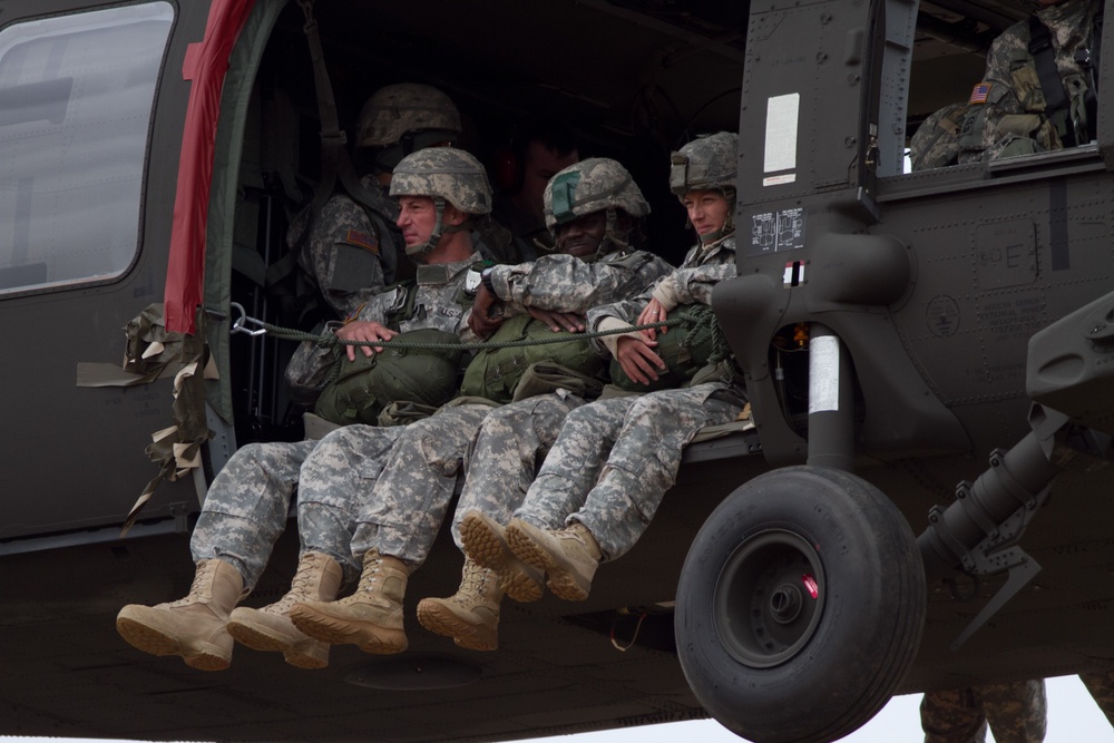 Paratroopers jump from helicopters