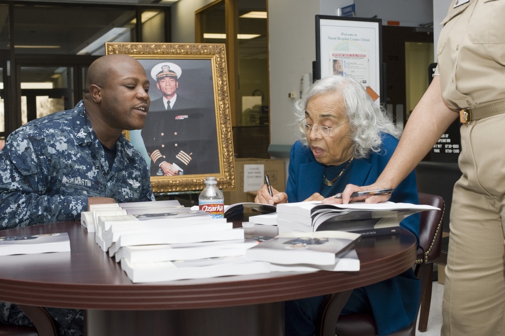 Widow of first African-American captain autographs book