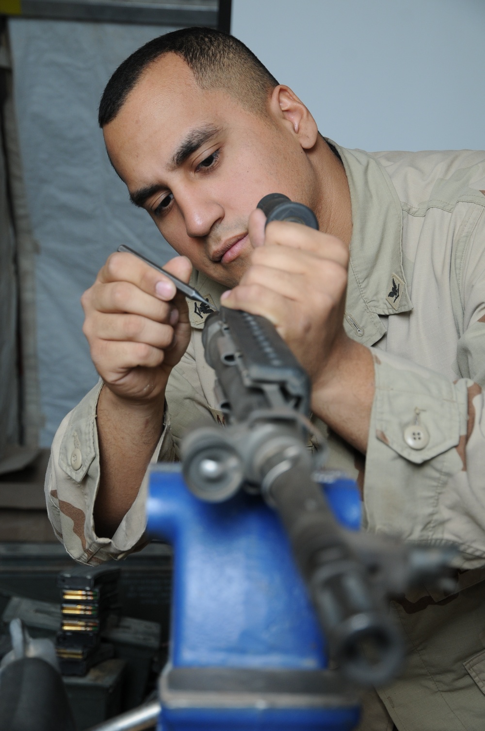 Seabee Gunners Mate Inspects a Machine Gun