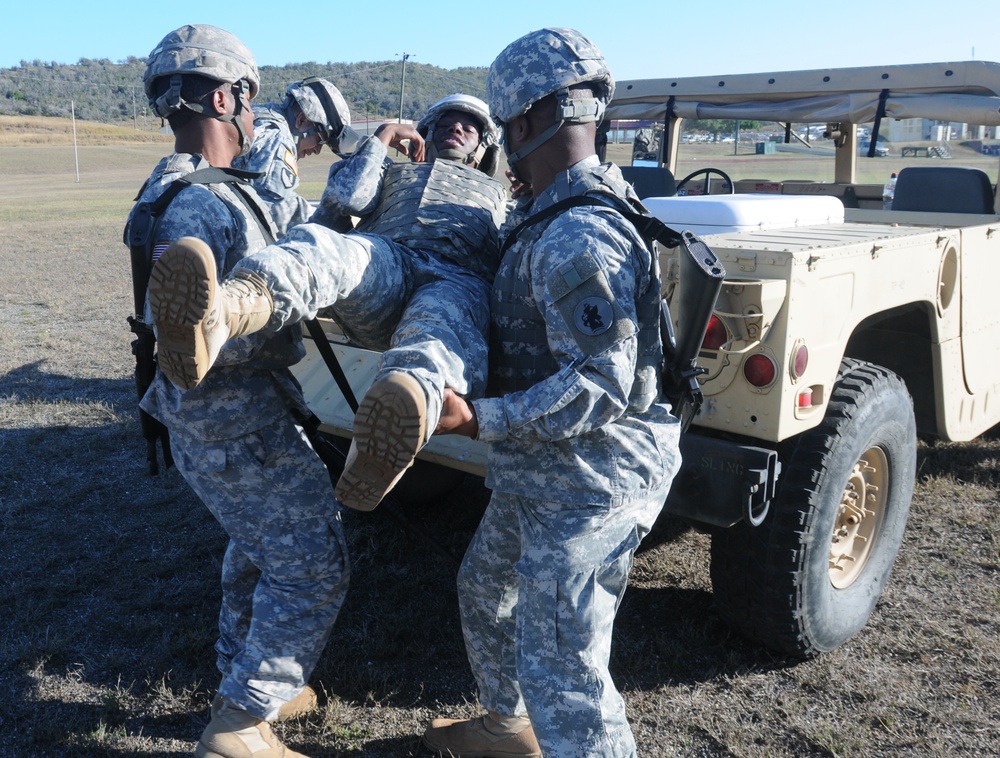 Soldiers from the 525th Military Police Battalion load an injured comrade into a tactical vehicle