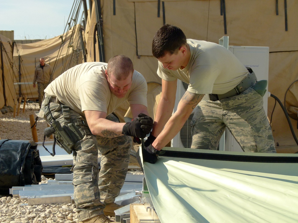 Members of U.S. Air Force 877th Expeditionary Prime Beef Squadron prepare to erect an Alaskan Small Shelter System in Camp Ghowrmach