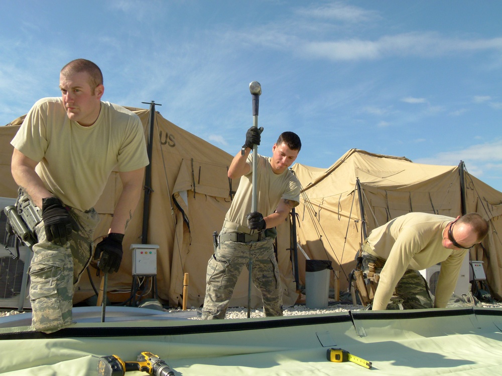 Members of U.S. Air Force 877th Expeditionary Prime Beef Squadron prepare to erect an Alaskan Small Shelter System at FOB Ghowrmach