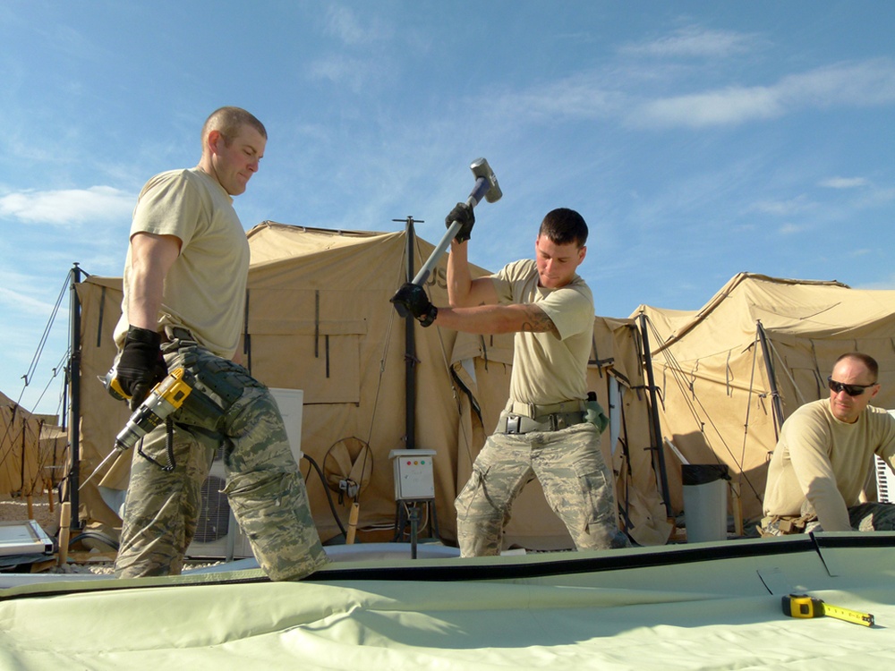 Members of U.S. Air Force 877th Expeditionary Prime Beef Squadron prepare to erect an Alaskan Small Shelter System at FOB Ghowrmach